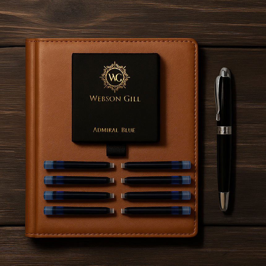 A leather notebook, Ink Refill Cartridge - Instant Insert for Webson Gill Fountain Pens (Blue Ink), a smudge-free black fountain pen, and a Webson Gill box labeled "Admiral Blue" arranged on wood.