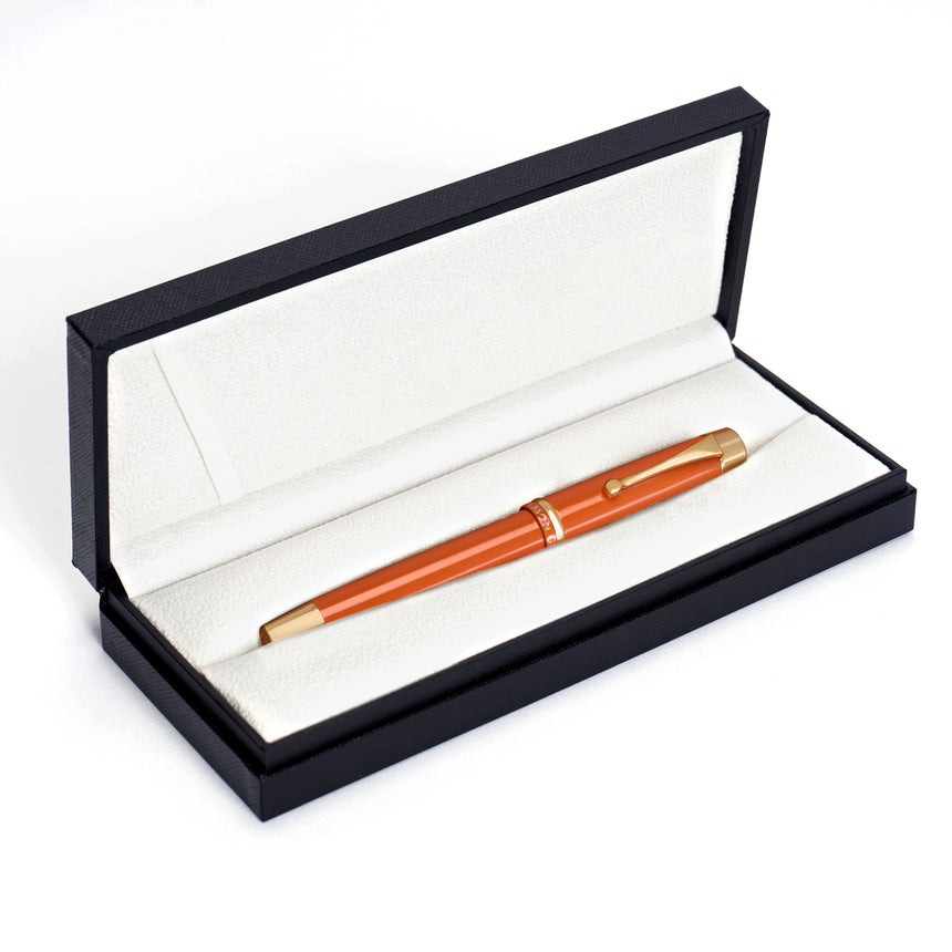 The Muse Fountain Pen by Webson Gill is an orange and gold writing instrument with an ergonomic design, showcased in an open black case with a white interior lining.