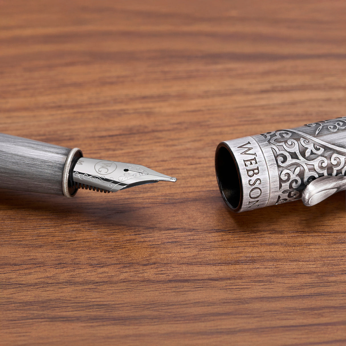 A close-up of the Webson Gill 'Admiral' Premium Fountain Pen, featuring an ornate metal cap, resting elegantly on a wooden surface.