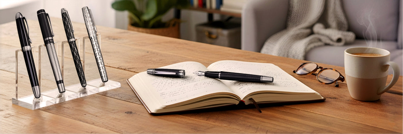 Four pens on a stand, an open notebook with a pen, glasses, and a coffee cup on a wooden table.