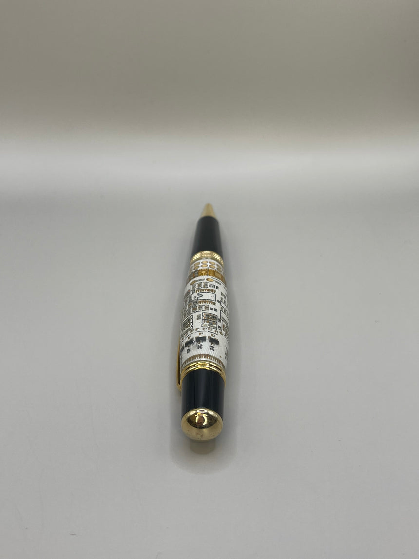 A Webson Gill "Techno Fusion" ballpoint pen by Webson Gill Archives, in black and gold with a printed label, stands upright on a plain surface—ideal for fans of modern sophistication and sleek design.