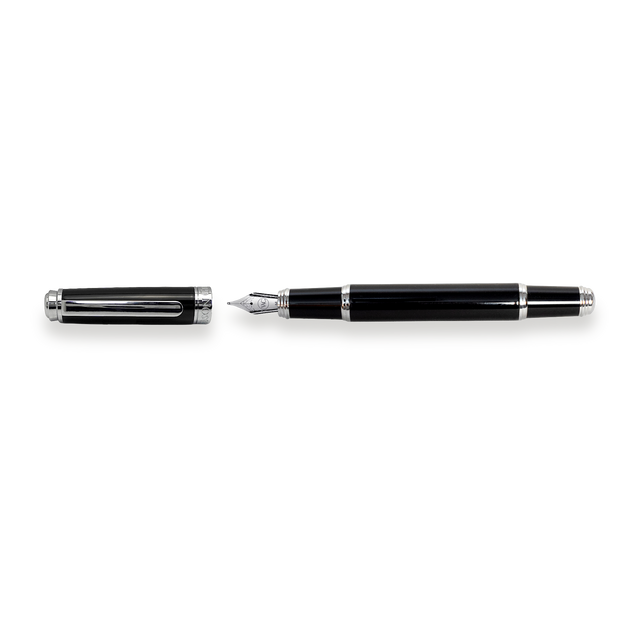 The Mogul Fountain Pen by Webson Gill, featuring a black body with silver accents and a stainless steel medium nib, lies next to its uncapped lid on a white background.