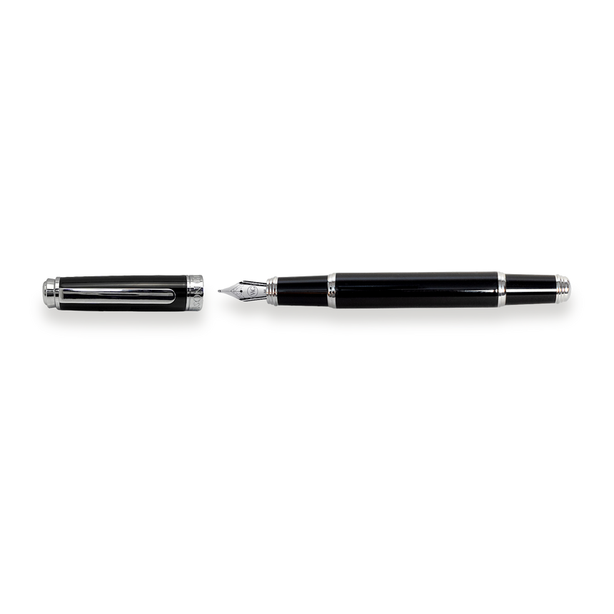 The Mogul Fountain Pen by Webson Gill, featuring a black body with silver accents and a stainless steel medium nib, lies next to its uncapped lid on a white background.