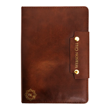 The Webson Gill Leather Writing Notebook features brown leather, gold accents, a strap closure engraved with the brand name, and premium fountain pen paper for a smooth writing experience.