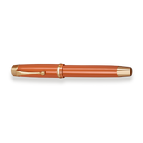 The Muse Fountain Pen by Webson Gill, in orange and gold with cap on and a gold-plated nib, is displayed horizontally on a white background.