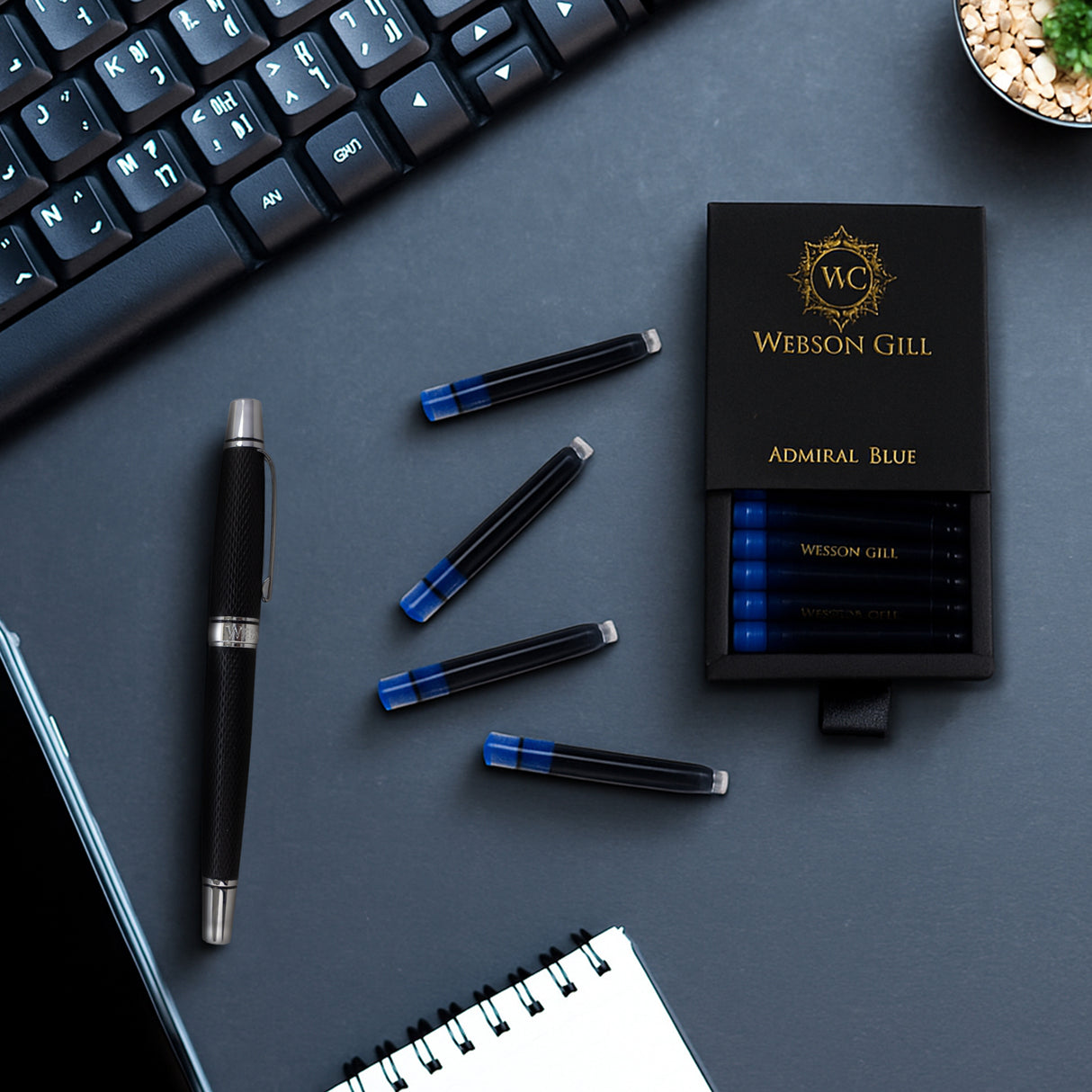 A Webson Gill Blue Ink Refill Starter Pack (2 cartridges), a fountain pen, keyboard, and notebook sit on a dark desk.