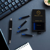 A Webson Gill Blue Ink Refill Starter Pack (2 cartridges), a fountain pen, keyboard, and notebook sit on a dark desk.