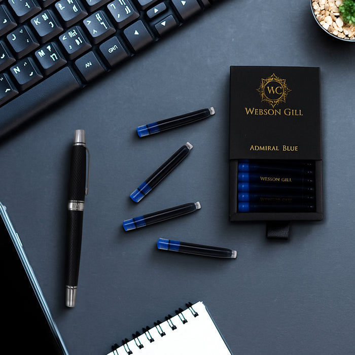 A Webson Gill Blue Ink Refill Starter Pack (2 cartridges), a fountain pen, keyboard, and notebook sit on a dark desk.
