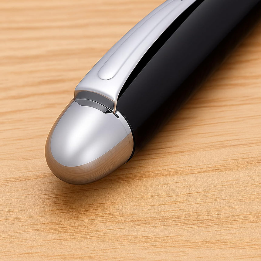 A close-up of WG's 'The Boss' Everyday Fountain Pen in black and silver, featuring a stainless steel nib, resting on a light wooden surface.