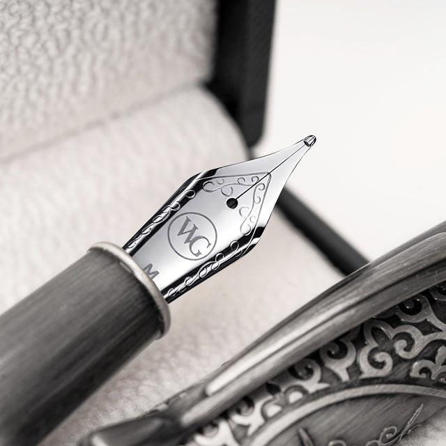 Close-up of the Admiral Fountain Pen by Webson Gill, featuring a silver nib with intricate designs and an antique silver finish, displayed in a decorative case.