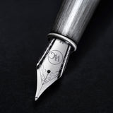 Close-up of the Admiral Fountain Pen by Webson Gill, featuring a silver nib with antique finish and intricate detailing on a dark background, emphasizing its elegant design.