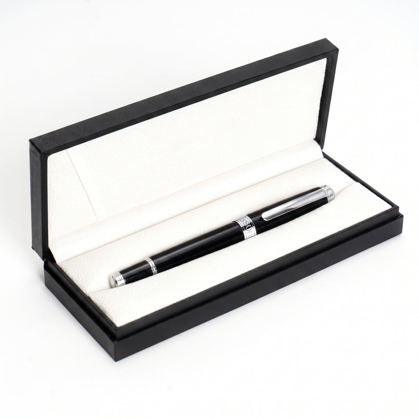 The Webson Gill 'The Mogul' Premium Ballpoint Pen, featuring a black luxury finish with silver accents, is elegantly displayed in an open black and white presentation box on a white background. It offers smooth ink flow for an exceptional writing experience.