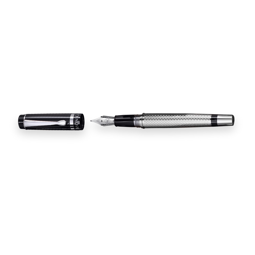 The WG ‘The Raider’ Everyday Fountain Pen, featuring a black and silver design with a textured barrel and stainless steel medium nib, rests beside its black cap on a white background.