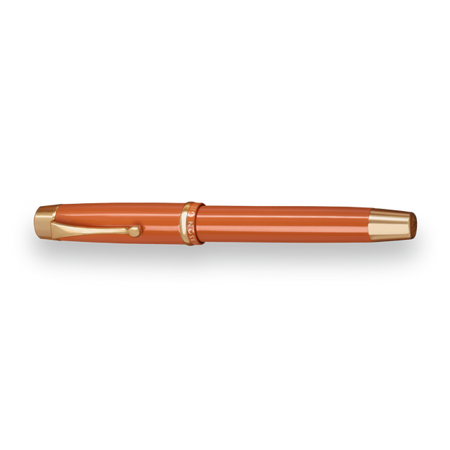 The Muse Fountain Pen by Webson Gill, with an orange body, gold-plated nib, gold accents, and a clip, is displayed on a white background.