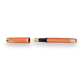 The Muse Fountain Pen by Webson Gill is an orange pen with an ergonomic design, featuring a gold-plated nib and a matching cap, both accented with gold.