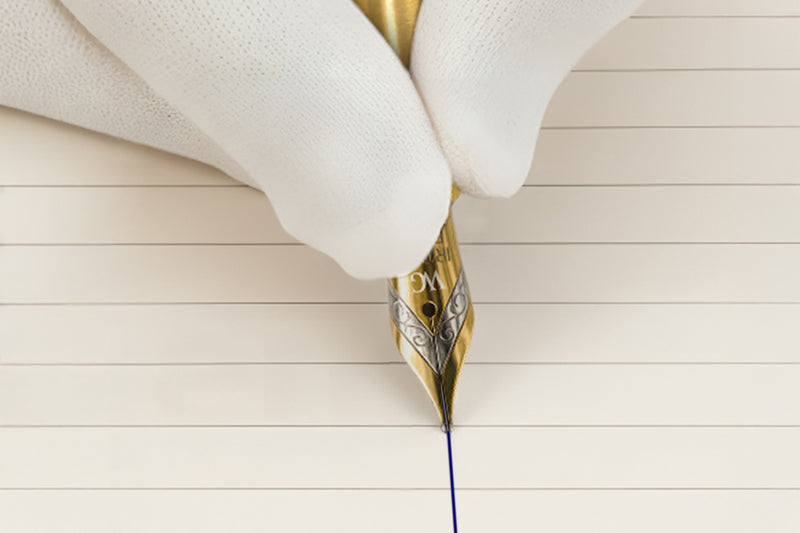 Close-up of a gloved hand writing with a gold fountain pen on lined paper.